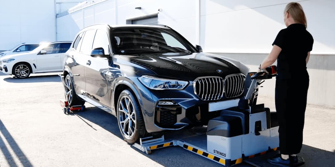 strong-press-arms-utilized-by-a-worker-moving-a-heavy-black-bmw