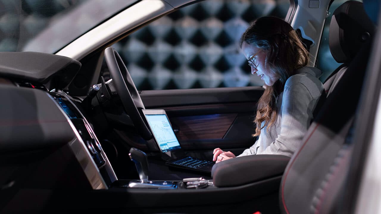 A production engineer working in a car, formulating plan on how to use a vehicle mover