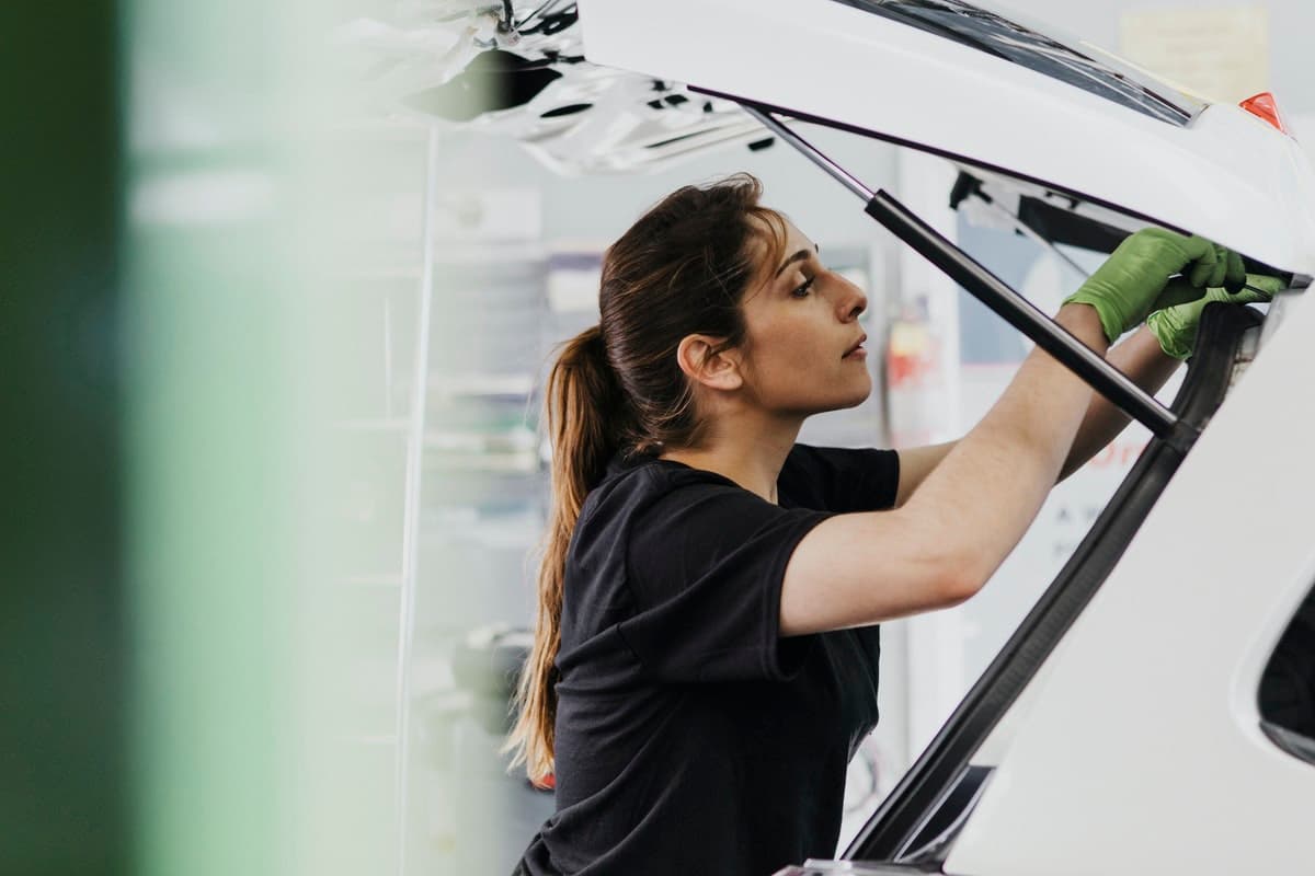 Femal-worker-safely-working-on-a-white-car